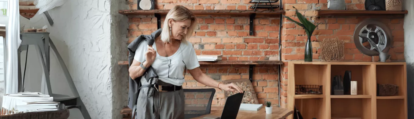 Une femme dans un bureau moderne, se préparant à quitter son poste, reflétant la gestion efficace des congés en 2025