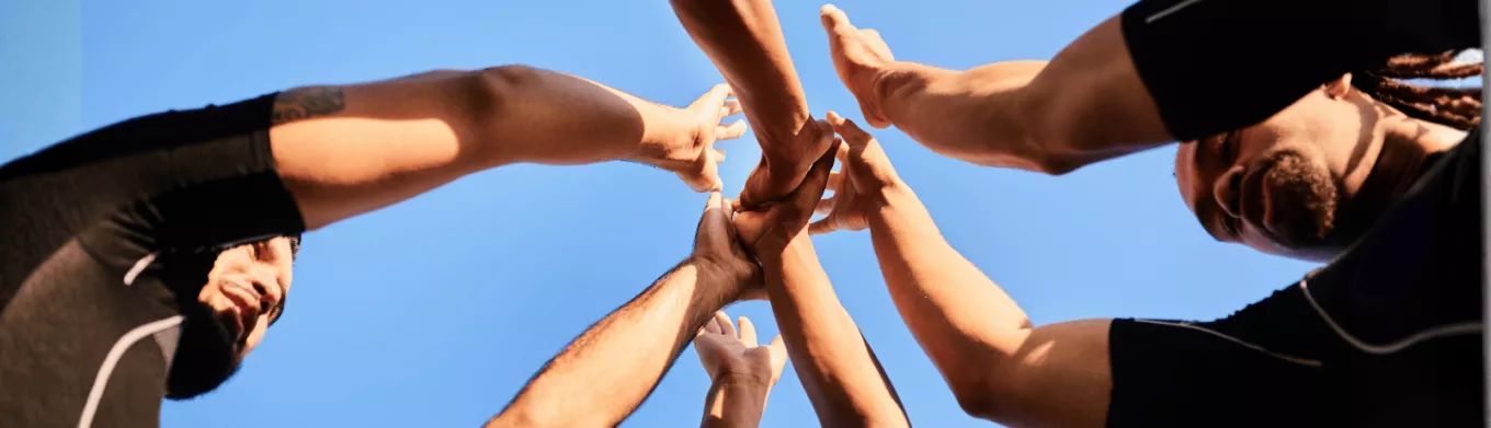 Employés rassemblant leurs mains symbolisant la cohésion d'équipe au Luxembourg
