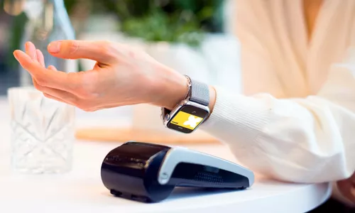 Une personne payant sur un terminal de paiement avec une montrée connectée en paiement mobile (Apple Pay ou Google Pay) avec sa carte Pluxee Gift au Luxembourg