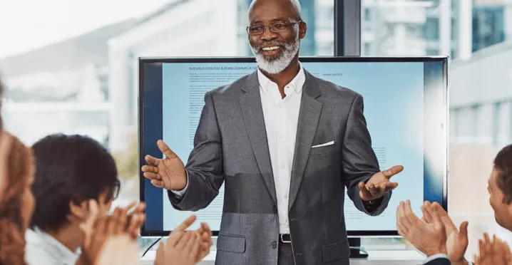 Un employé heureux, applaudi et reconnu par ses collègues