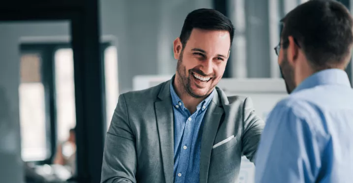 Deux hommes se serrant la main en entreprise à l'occasion d'une entrée en fonction avant transmettre la culture de l'entreprise