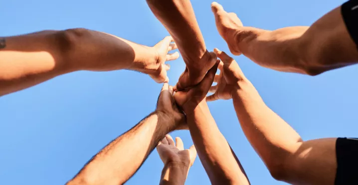 Employés rassemblant leurs mains symbolisant la cohésion d'équipe au Luxembourg