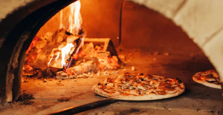 Pizza au feu de bois sortant du four