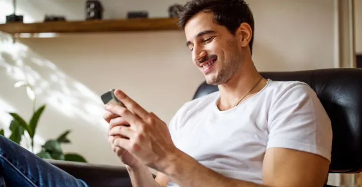 Personne assise consultant les offres Pluxee au Luxembourg sur son smartphone.