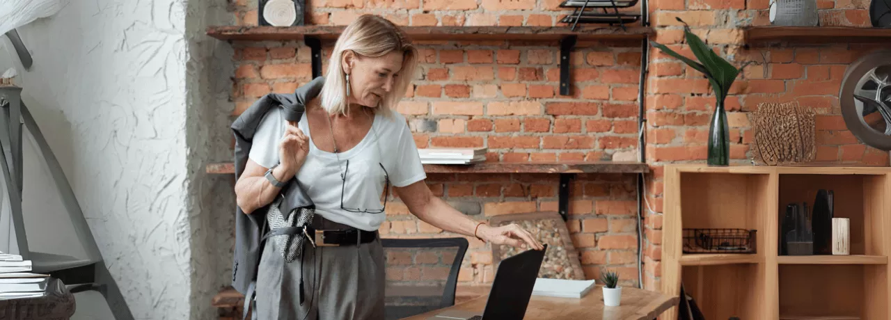 Une femme dans un bureau moderne, se préparant à quitter son poste, reflétant la gestion efficace des congés en 2025