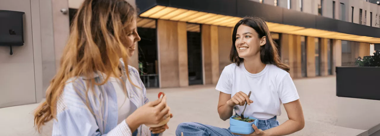 2 collègues en train de déjeuner grâce à leur chèques repas Pluxee dont la valeur faciale a augmenté au Luxembourg