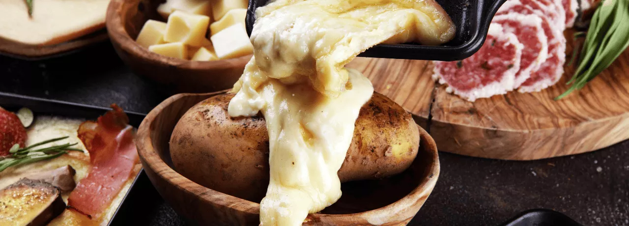 Raclette coulant sur une pomme de terre pour la saison hivernale 