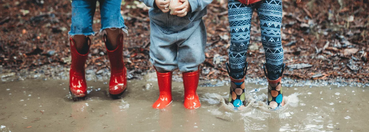 Enfants qui jouent dans la pluie pour s'occuper quand il ne fait pas beau au Luxembourg