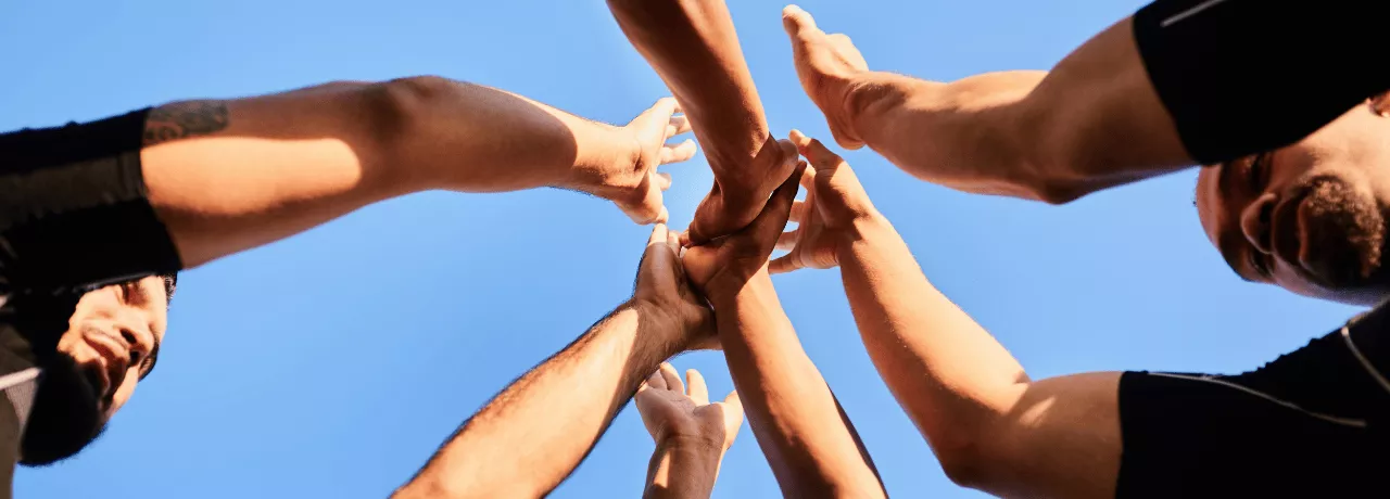 Employés rassemblant leurs mains symbolisant la cohésion d'équipe au Luxembourg