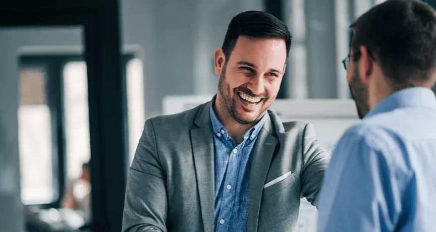 Deux hommes se serrant la main en entreprise à l'occasion d'une entrée en fonction avant transmettre la culture de l'entreprise