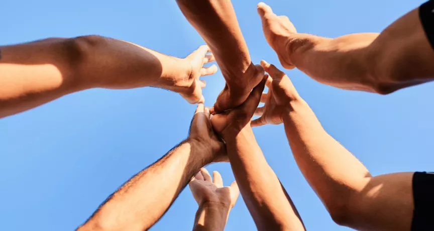 Employés rassemblant leurs mains symbolisant la cohésion d'équipe au Luxembourg