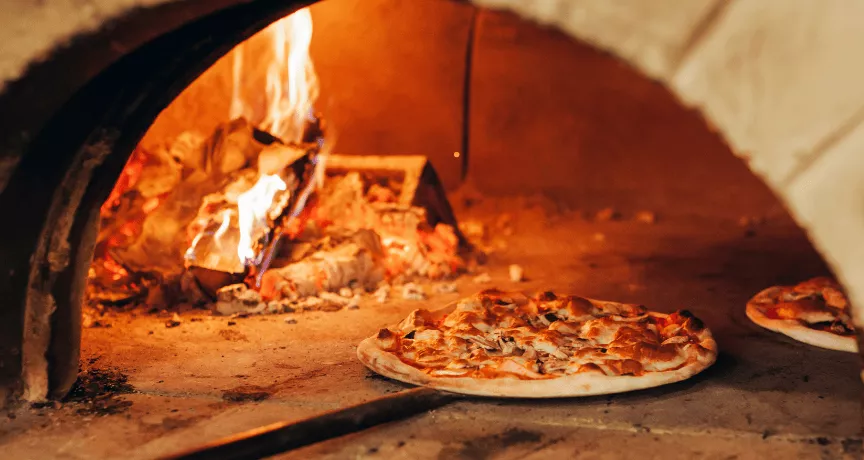 Pizza au feu de bois sortant du four