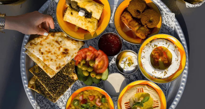 Plat végétarien sur un plateau : falafel, olives, naan, tzatziki, Baba ganousch