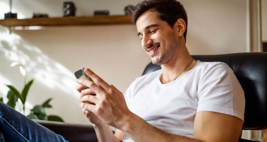Personne assise consultant les offres Pluxee au Luxembourg sur son smartphone.
