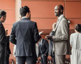 Des professionnels en discussion dans un espace de conférence moderne, illustrant l'importance du networking pour élargir son réseau
