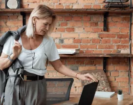 Une femme dans un bureau moderne, se préparant à quitter son poste, reflétant la gestion efficace des congés en 2025