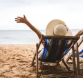 Personne détendue sur une chaise longue face à la mer, symbole de la déconnexion pendant les vacances – Pluxee Luxembourg