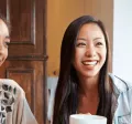 Groupe de femmes souriantes partageant un café, symbole de convivialité et d’intégration sociale pour les nouveaux arrivants au Luxembourg