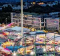 Schueberfouer Luxembourg au coucher du soleil avec grande roue illuminée, manèges et attractions: idée de sortie familiale avant la rentrée scolaire, recommandée par Pluxee Luxembourg.