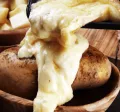 Raclette coulant sur une pomme de terre pour la saison hivernale 