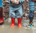 Enfants qui jouent dans la pluie pour s'occuper quand il ne fait pas beau au Luxembourg