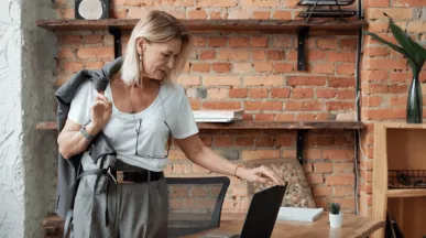 Une femme dans un bureau moderne, se préparant à quitter son poste, reflétant la gestion efficace des congés en 2025