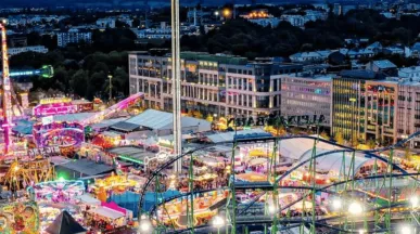 Schueberfouer Luxembourg au coucher du soleil avec grande roue illuminée, manèges et attractions: idée de sortie familiale avant la rentrée scolaire, recommandée par Pluxee Luxembourg.