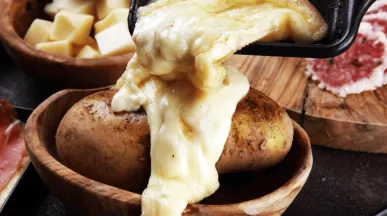 Raclette coulant sur une pomme de terre pour la saison hivernale 