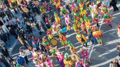 Des personnes défilant pour le carnaval au Luxembourg dans la rue avec un public qui regarde le défilé
