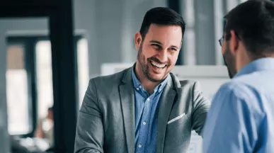 Deux hommes se serrant la main en entreprise à l'occasion d'une entrée en fonction avant transmettre la culture de l'entreprise