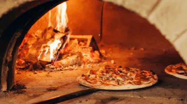 Pizza au feu de bois sortant du four