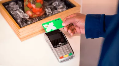 Une personne payant sur un terminal de paiement au Luxembourg avec sa carte Pluxee Lunch