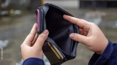 Portefeuille vide tenu dans les mains d’une personne illustrant des difficultés financières ou une perte de pouvoir d’achat.