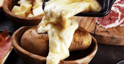 Raclette coulant sur une pomme de terre pour la saison hivernale 