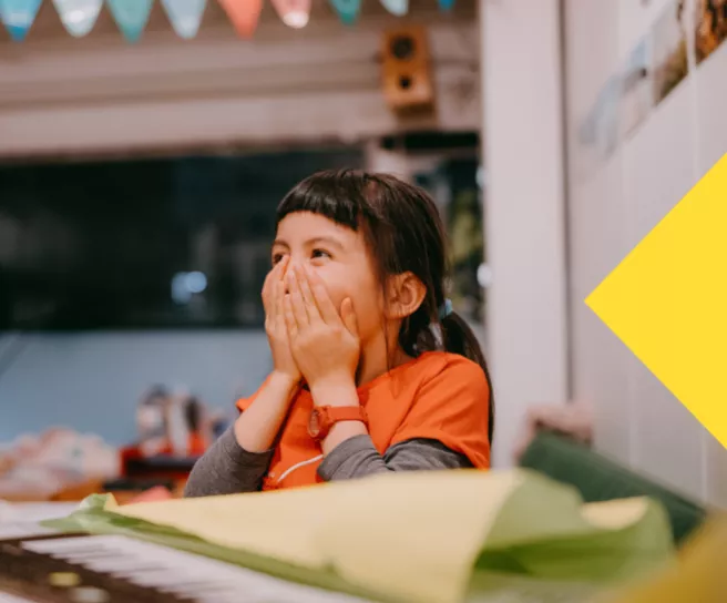 Enfant surprise et heureuse de recevoir un cadeau acheté grâce à une carte Pluxee gift