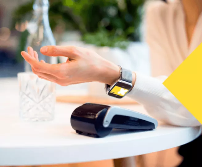 Une consommatrice Pluxee payant sur un TPE avec sa montre connectée via Apple Pay avec sa carte Pluxee Gift virtuelle